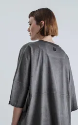 Remera de manga corta, calce extra oversize, color gris oscuro con efecto gastado/degradado. Presenta roturas y detalles deshilachados en cuello, hombros y puños.