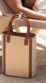 Matera color beige con estampado símil piel de serpiente, con detalles en cuero marrón y correa larga desmontable.
