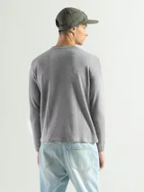 Remera negra de manga larga con cuello redondo, confeccionada en tejido mini piqué de algodón.