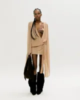 Vestido corto color beige con escote cruzado, mangas largas acampanadas y falda corta.