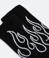 Par de medias de caña alta negras con estampado de llamas blancas.