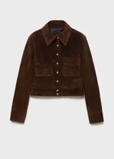 Chaqueta corta marrón de gamuza con cuello camisero, cierre frontal con botones a presión, dos bolsillos de parche con solapa en el pecho y puños abotonados.