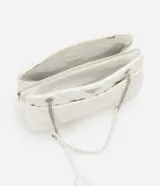 Bolso de hombro mediano color blanco con diseño acolchado en forma de rombos. Tiene asa de cadena plateada, cierre de cremallera y bolsillo frontal con botón a presión.
