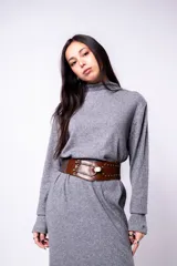 Vestido midi gris de punto, con cuello alto y mangas largas. Incluye cinturón ancho de cuero marrón con hebilla metálica.
