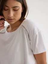 Remera negra de algodón con mangas cortas con detalle de calado y bordado en los hombros y mangas. Corte recto con cintura ajustable con cordón.