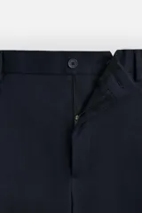 Pantalón de vestir azul marino, de corte recto, con pinzas frontales, bolsillos laterales y traseros con doble vivo y botón.