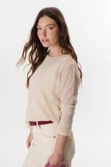 Sweater beige de tejido de punto calado, con mangas largas y cuello redondo. Confeccionado en viscosa y poliéster.