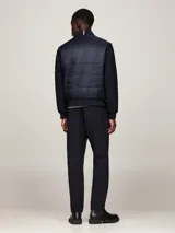 Campera bomber azul marino con mangas largas, cuello, puños y bajo acanalados. Presenta cierre frontal con cremallera, dos bolsillos laterales y logo de Tommy Hilfiger bordado en el pecho.