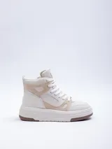Zapatilla acordonada de caña media, color blanco, con plataforma de 5 cm y recortes irregulares.
