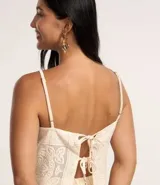 Blusa cropped de algodón con escote recto, breteles finos ajustables, lazo doble en la espalda y estampa floral guipire.