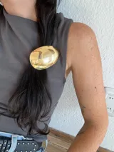 Colita de pelo dorada con aplique metálico ovalado.