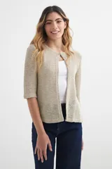 Cardigan de punto color beige, con mangas 3/4 y cierre con un botón.