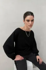 Sweater negro tramado de silueta relajada, con combinación de texturas en el tejido y mangas abullonadas con puños elastizados.