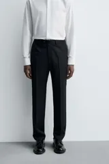 Pantalón de vestir negro de lana, corte recto, con bolsillos laterales y traseros de ojal con botón.