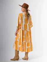 Vestido midi de corte amplio con estampado abstracto en tonos azules, blancos y beige. Tiene cuello en V, mangas 3/4 con volados y corte escalonado en la falda.