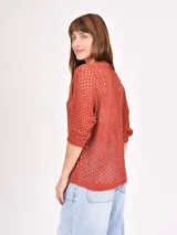 Buzo de tejido de punto calado color negro, con escote en V y mangas 3/4.