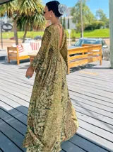 Vestido largo de polysilk con estampado paisley en tonos azul, celeste y dorado. Tiene escote en V, mangas largas acampanadas y corte amplio.