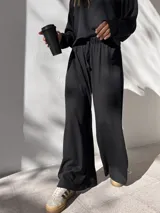 Pantalón negro de tela waffle de algodón, con cintura elastizada y cordón ajustable.