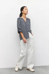Camisa de manga larga con estampado en color negro y blanco, escote en V y cuello mao, con detalles de plisados y bordados.