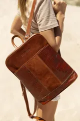 Mochila de cuero marrón, con diseño elegante y detalles en relieve.