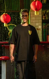 Remera negra de algodón con corte holgado y estampado frontal de un demonio con cuernos en color amarillo.