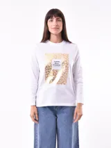 Remera blanca de manga larga con estampa rectangular dorada con diseño animal print y texto 'Fearless, fierce & fabulous'.