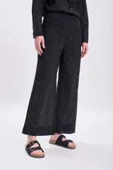 Pantalón negro con bordado calado, de corte palazzo y tiro alto.