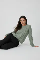 Sweater de poliéster color verde menta, con cuello redondo a la base, diseño de ochos y corte holgado.