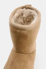 Botín color arena con interior de efecto pelo y suela tipo flatforma.