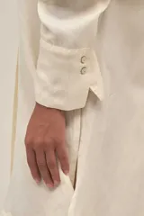 Camisola corta color crema confeccionada en lino-tencel con botones nacarados y bolsillos laterales.