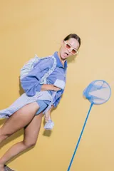 Bolso tipo cartera de nylon con diseño plisado y estampado abstracto en tonos claros.