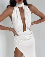 Vestido blanco de corte midi, con escote halter y abertura en la pierna.