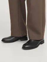 Botas Chelsea negras de cuero, con elásticos laterales y suela de goma.