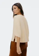 Blusa color crema con escote en V y mangas cortas amplias.