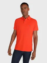 Chomba naranja de Tommy Hilfiger, corte regular, con cuello tipo chomba, cartera de dos botones, logo de la marca bordado en el pecho y mangas cortas.