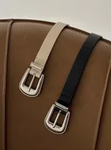 Cinturón negro de cuero ecológico con hebilla metálica plateada de estilo western.