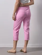 Pantalón capri color rosa de tencel elastizado con bolsillos simulados en la parte delantera y bolsillos aplicados en la parte trasera. Tiene pretina ancha, corte recto y terminación de ruedo desflecado.