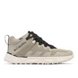 Bota de senderismo Columbia, modelo Facet 75 Mid OutDry, color gris topo con cordones negros y suela blanca gruesa con tacos. Presenta tecnología OutDry impermeable y transpirable, sistema Navic Fit y amortiguación TechLite Plush.