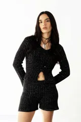 Buzo negro de lurex con tajo delantero y mangas largas.