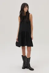 Vestido corto negro de lino, corte evasé, sin mangas y con escote redondo.