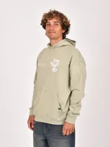 Buzo con capucha color marrón, de tejido liso, con bolsillo canguro frontal y puños y ruedo acanalados. Presenta un pequeño logo circular en la parte inferior del bolsillo.