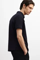 Remera polo negra de piqué de algodón, de corte estándar, con cuello clásico, tapeta de botones, mangas cortas y remate acanalado en cuello y mangas.