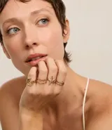 Set de seis anillos dorados de metal reciclado, con diseños delicados y motivos marinos como una espiral y una estrella de mar.