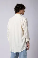 Camisa color arena de lino, manga larga, con cuello clásico y corte holgado.