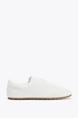 Zapato deportivo tipo blucher color blanco con suela marrón.
