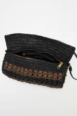 Bolso de hombro con cuerpo trenzado en color negro y marrón. Tiene detalle metálicos circulares en los laterales, asa de hombro, bolsillo interior con cremallera y cierre mediante solapa y cremallera.