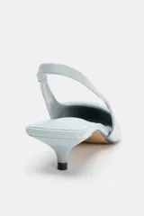 Zapato destalonado color celeste con taco kitten y aplique en la parte delantera.