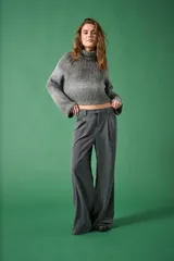 Sweater gris de punto con cuello alto y mangas largas. Diseño de punto acanalado y corte cropped. Ideal para uso casual.