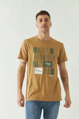 Remera color ocre de manga corta con cuello redondo y estampado frontal con texto en verde y blanco.