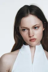 Vestido midi blanco, con cuello halter y falda con terminación en godets, lo que le da volumen y movimiento.